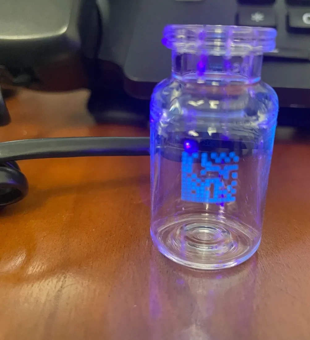 A real vial with an inkjet-printed code glowing under the reader's light